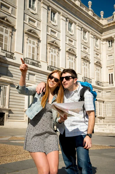 Friends tourist couple visiting Madrid in holidays visiting town happy with city map
