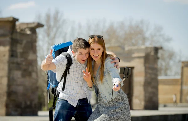 Young American student and tourist couple visiting Egyptian monument taking selfie photo with stick