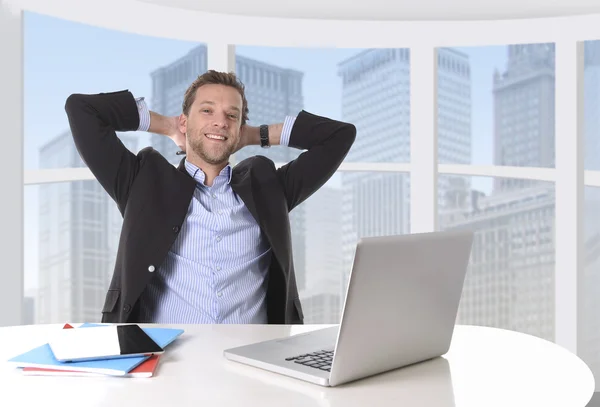 Attractive businessman happy at work smiling relaxed at computer business district office