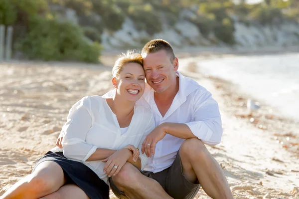 Attractive beautiful  couple in love sitting on the beach in romantic summer holidays