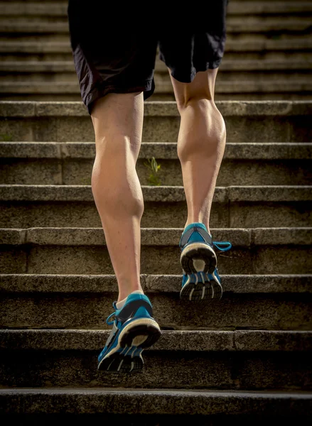 Young athletic legs with sharp scarf muscles of runner sport man climbing up city stairs jogging and running in urban training workout