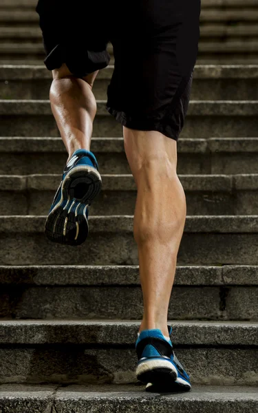 Young athletic legs with sharp scarf muscles of runner sport man climbing up city stairs jogging and running in urban training workout