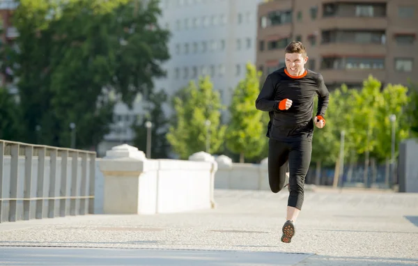 Young athletic man running on urban city park in summer sport training session
