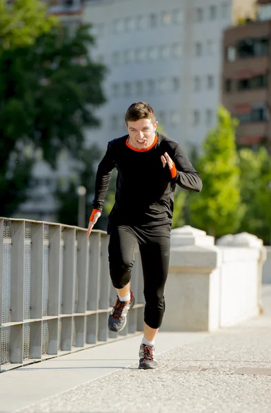 Young athletic man running on urban city park in sport training session