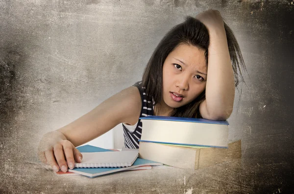 Young pretty chinese asian student woman bored tired and overworked leaning on school books studying