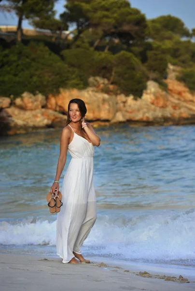 Attractive and beautiful woman enjoying vacation summer holidays at Spain coast village walking on beach