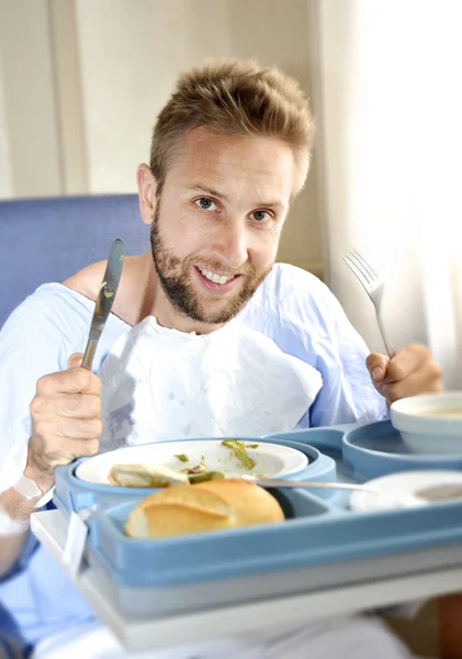 Man in hospital room eating healthy diet clinic food in happy satisfied face expression
