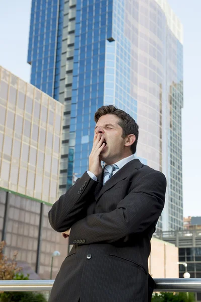 Exhausted tired businessman yawning in need of sleep after long hours of work