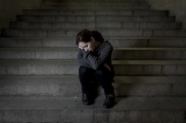 Sad woman alone on street subway staircase suffering depression looking looking sick and helpless