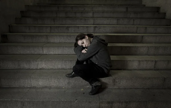 Sad woman alone on street subway staircase suffering depression looking looking sick and helpless