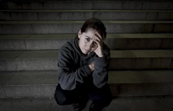 Sad woman alone on street subway staircase suffering depression looking looking sick and helpless