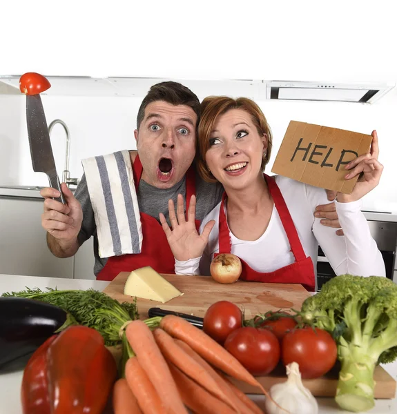 American couple in stress at home kitchen in cooking apron asking for help frustrated