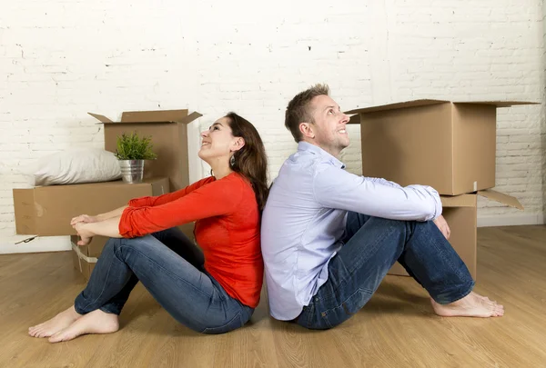 Happy couple sitting on floor celebrating moving in new flat house or apartment