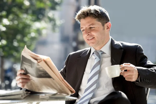 Businessman sitting outdoors for breakfast pause morning reading news in newspaper having coffee
