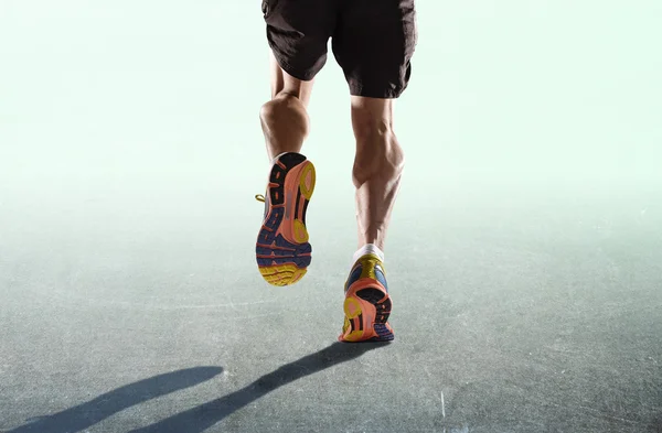 Athletic legs and running shoes of sport man jogging isolated in fitness healthy endurance concept in advertising style