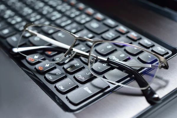 Eyeglasses on keyboard of notebook computer