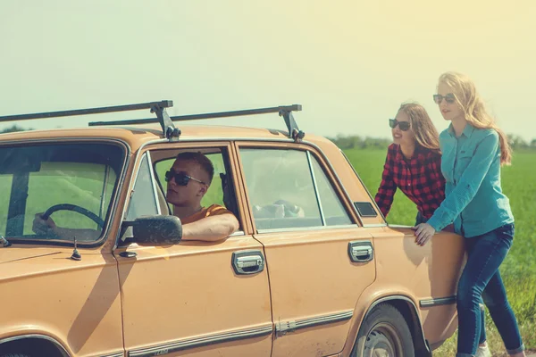 Young hipster friends on road trip on a car