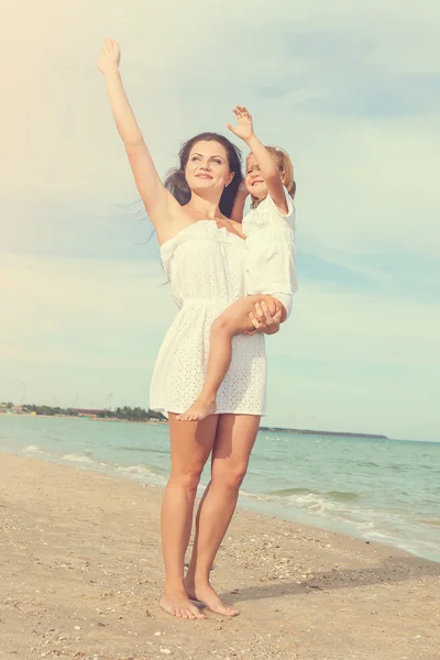 Happy beautiful mother and daughter enjoying beach time