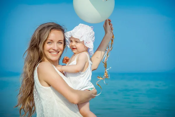 Happy beautiful mother and daughter enjoying beach time