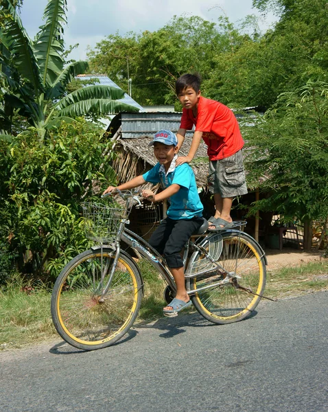 Asian children ride bicycle in danger