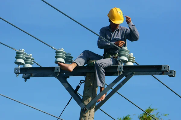 Asian electrician climb high, work on electric pole