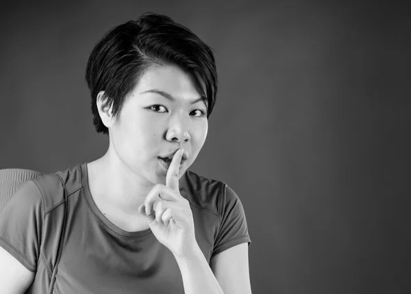 Woman asking for silence with finger on lips
