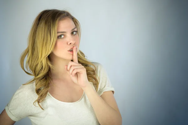 Woman asking for silence with finger on lips