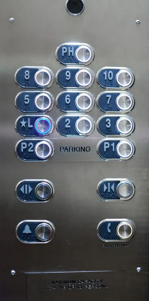 Full frame of numbered buttons with braille markings on elevator panel