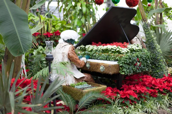Sculpture of man playing a piano alone in Allan Gardens