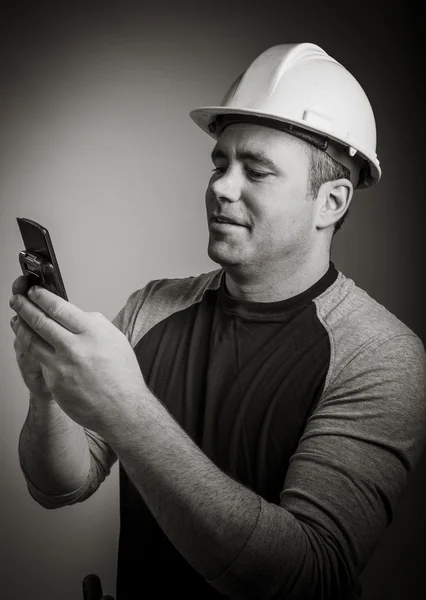 Man in protective helmet using mobile phone