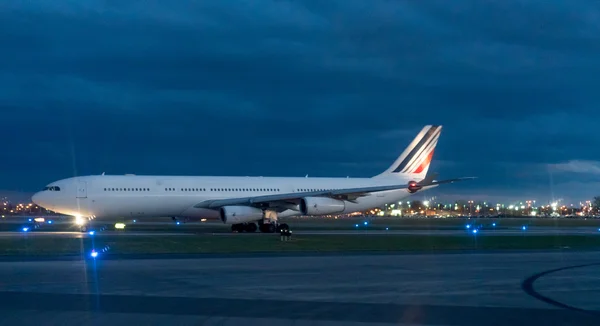 Airplane standing on runway at airport in night