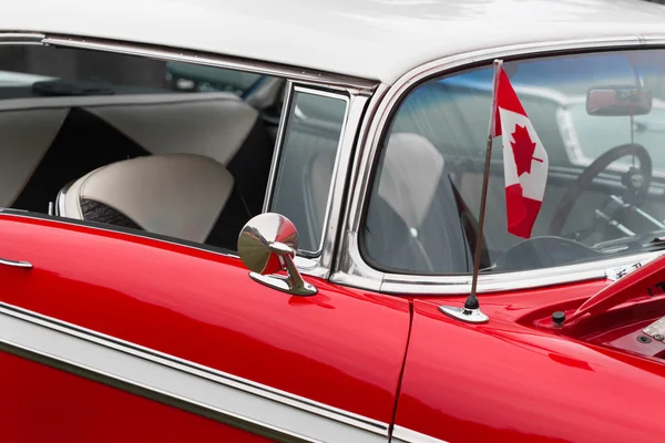 Canadian flag on bonnet of a red car