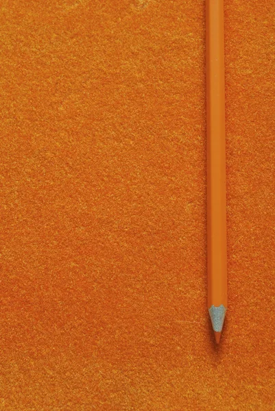 Orange pencil on orange texture background