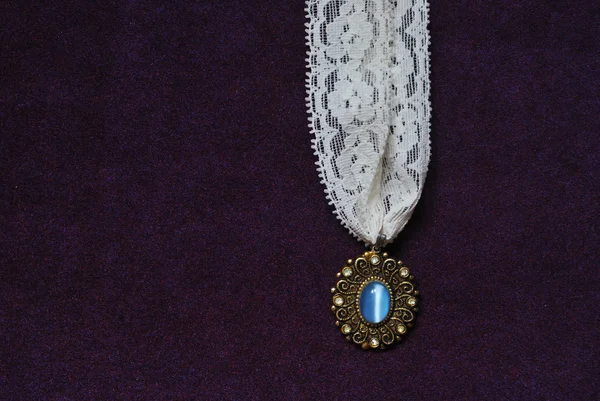 Photo of moonstone necklace with white lace on purple velvet background