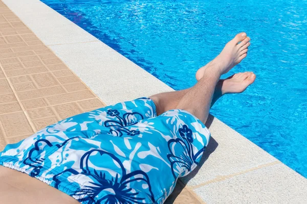 Teenage boy sunbathing at swimming pool
