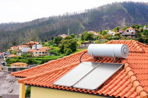 Water boiler with solar panels on roof of house