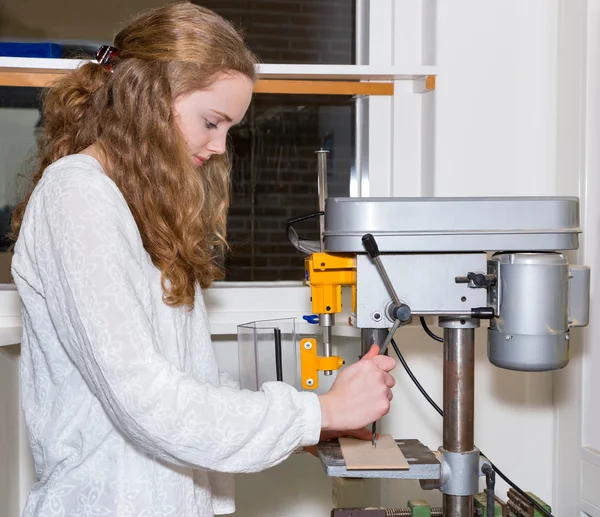 Dutch teenage girl operating electric drilling machine