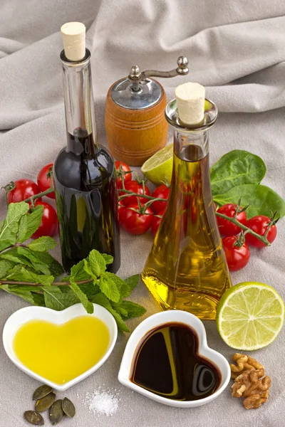 Oil and vinegar in heart shaped bowls displayed with fresh produ