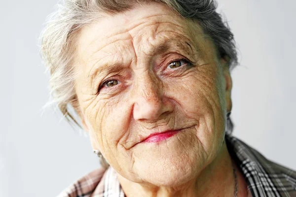 Looking old woman portrait on a grey background