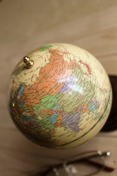 Small globe and glasses are on the table