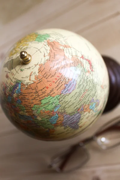 Small globe and glasses are on the table