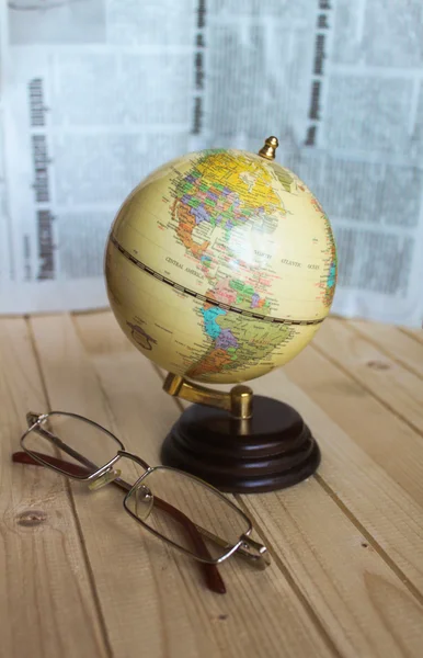 Small globe and glasses are on the table