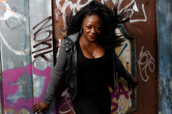 Smiling Black Woman Posing at Wall with Vandals