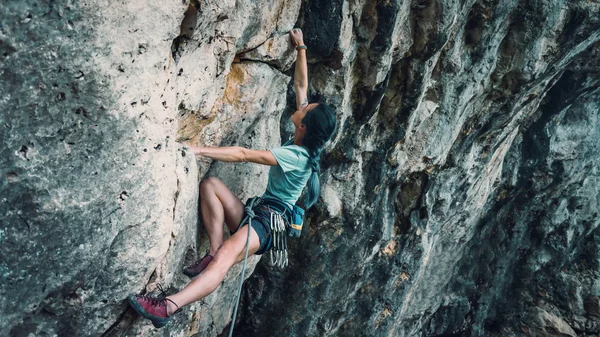 Woman with outfit climbing the rock