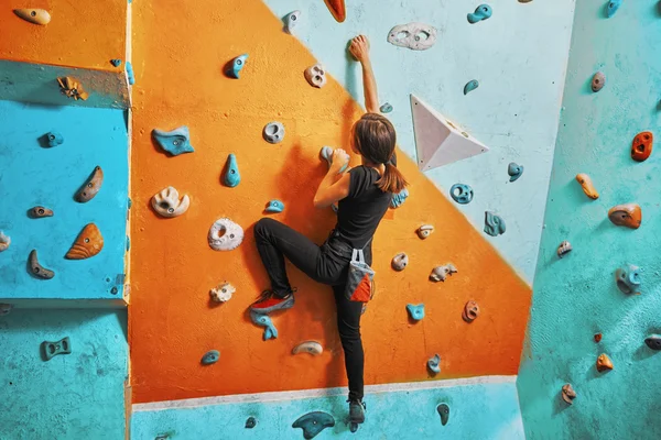 Woman climbing up wall