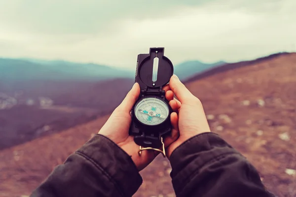 Hiker woman searching direction with compass