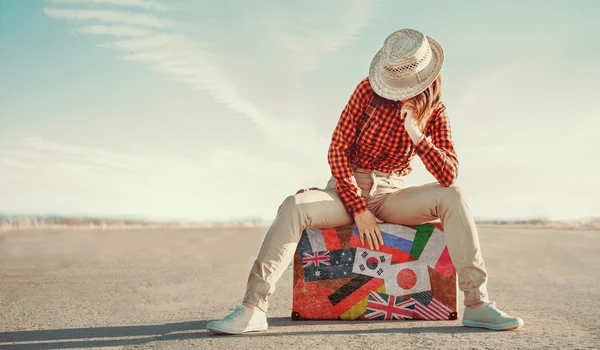 Traveler woman sitting on suitcase