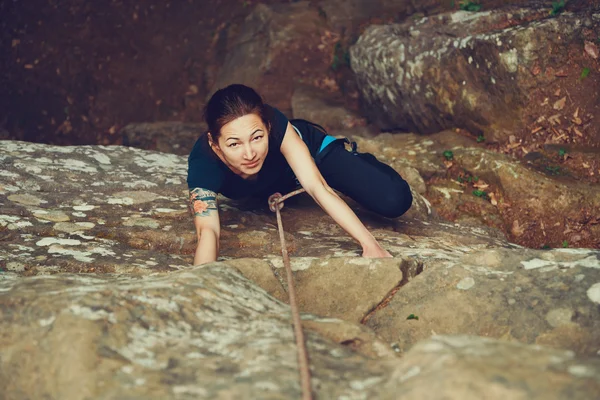 Woman climbing on stone rock