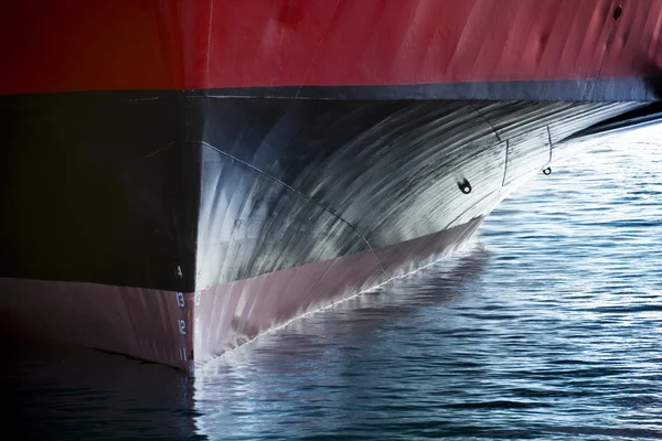 A beautiful vertical graphic view of the bow of a large ship in port would make a great cover image of anything involving international shipping transportation industrial cargo or ferry