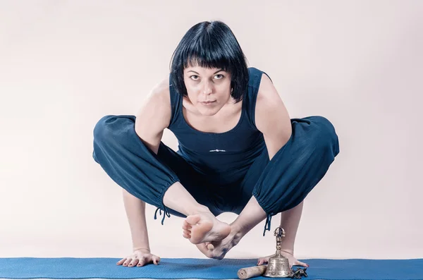 Slim brunette woman  doing yoga exercise.